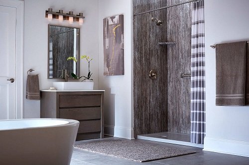 A large white bathroom with a walk-in shower, brown vanity, and oval, standalone tub. 